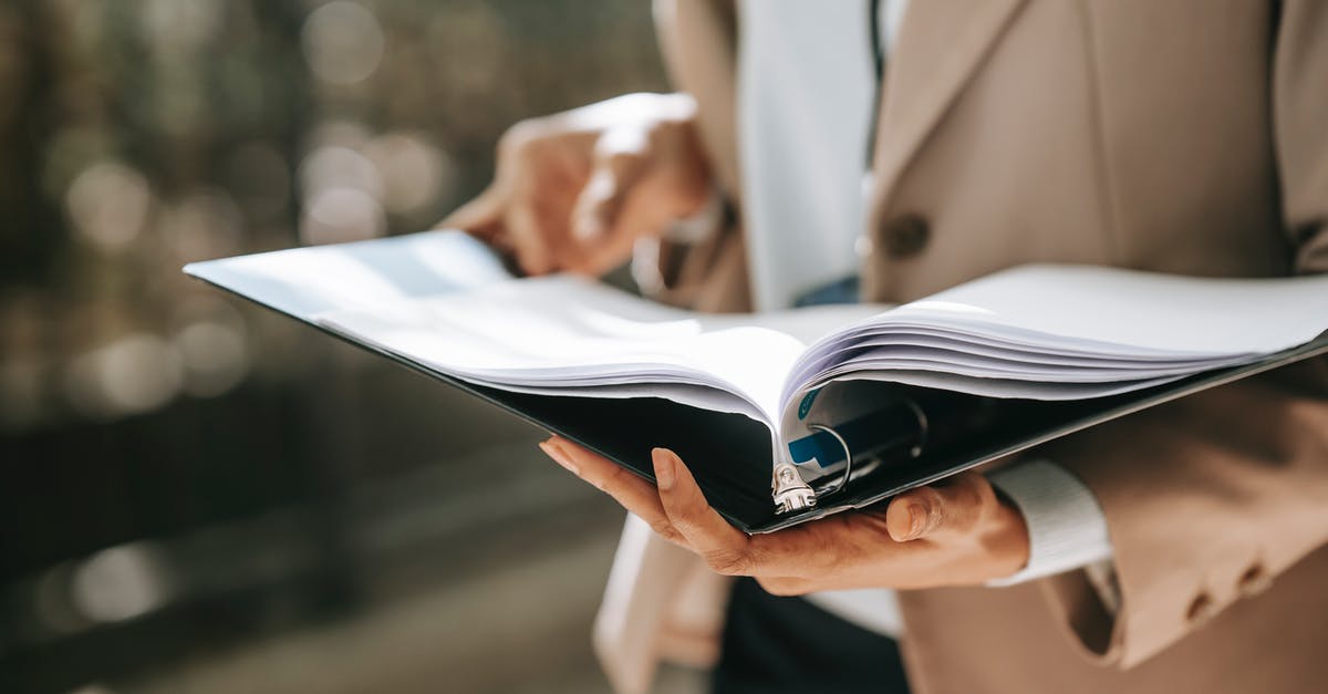 Stuck on black loading screen after cinematic for "The Devil by the Well" contract - Crop faceless female entrepreneur in formal jacket turning pages of documents in folder while reading