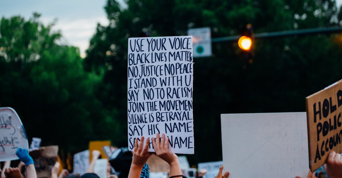 SW:L, in Trials of the Dragon, Trial of Fire - which solution is the right one? - Back view crowd of crop anonymous activists showing banners with anti racism slogans during protest on street