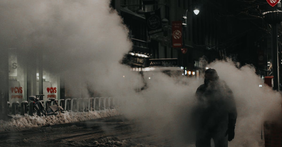 symlink to move steam games to cold storage? - Anonymous person in warm wear walking through street steam in modern NYC district in winter evening