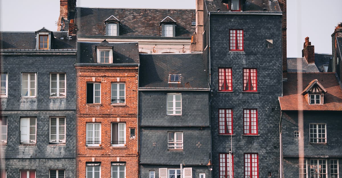 Tali on the Normandy location - Row of old historic stone residential houses with chimneys and windows located in Honfleur town on sunny day