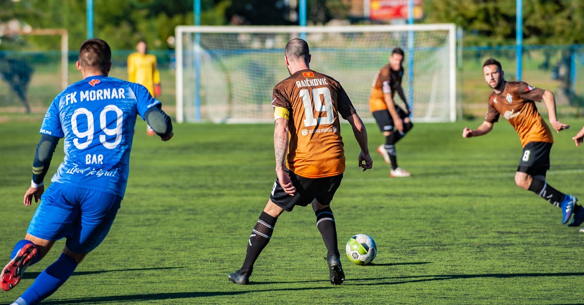 Team cohesion in football manager starting squad/reserves - Photo Of Men Playing Soccer During Daytime