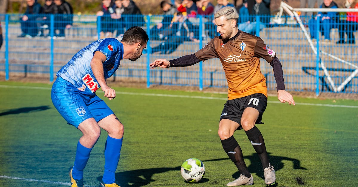 Team cohesion in football manager starting squad/reserves - Photo Of Man Playing Soccer During Daytime