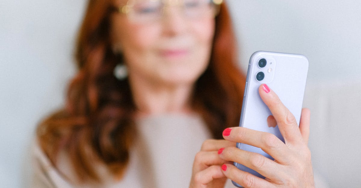 Tellraw or a message in chat at a certain 𝑦 level in Minecraft Bedrock? - Crop aged redhead female in eyeglasses using contemporary mobile phone while surfing internet in soft focus