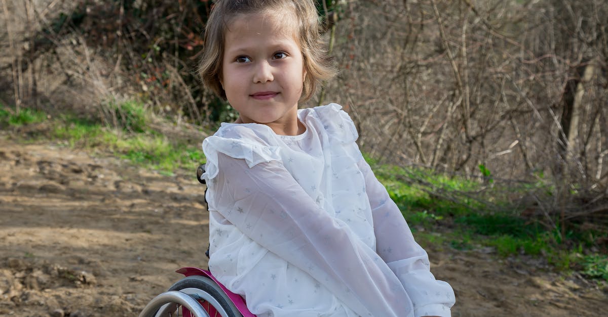Terraria Invalid Housing? [duplicate] - Adorable disabled girl in white clothes looking away while sitting in wheelchair on sandy ground in nature with growing trees