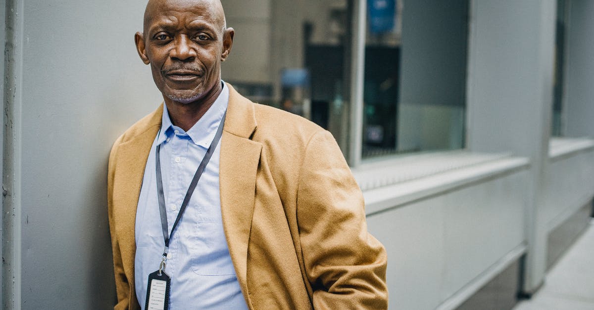 Terraria: Wall of Flesh Expert Mode - Positive African American businessman in formal suit leaning on contemporary building wall and looking at camera thoughtfully