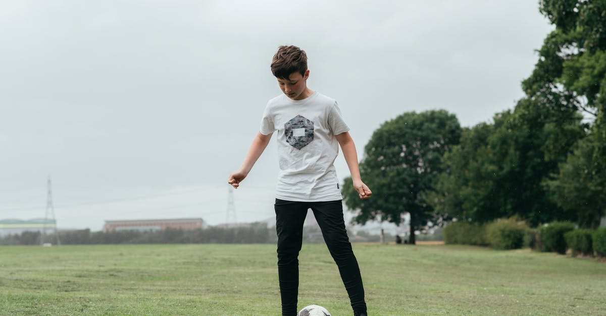 /testfor moving player [duplicate] - Concentrated boy playing football in field