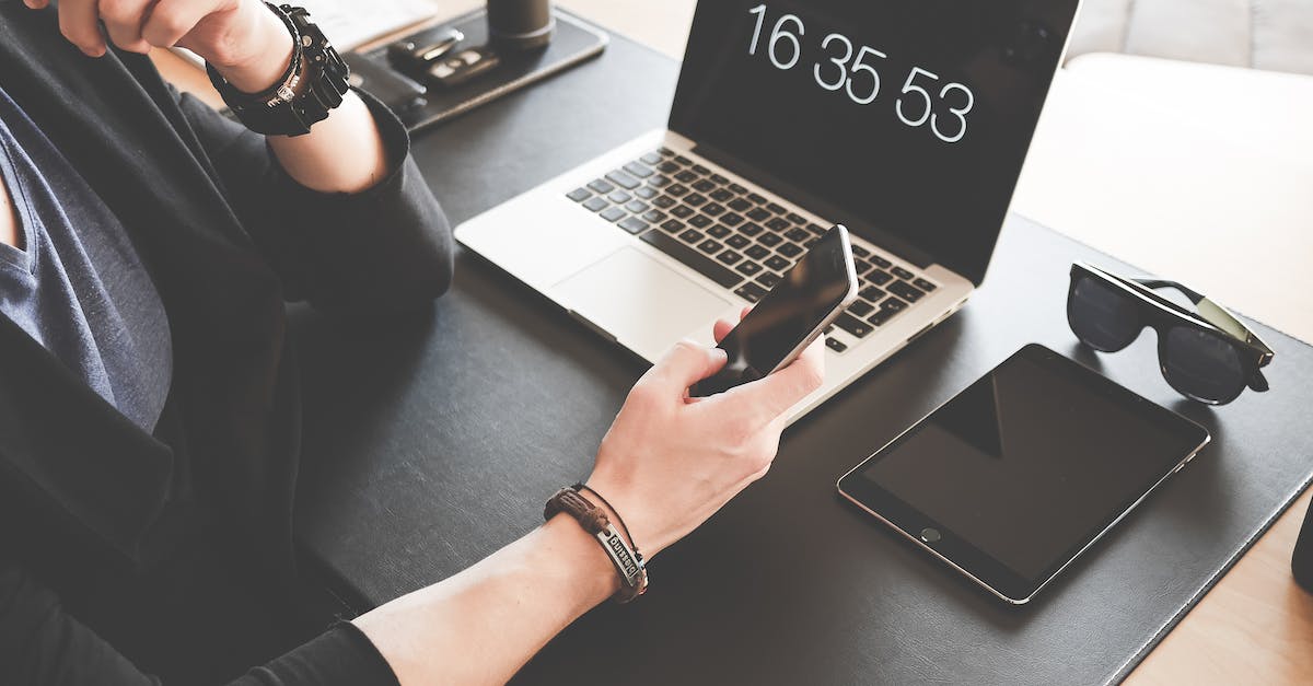 TF2 Black Screen on launch? - Woman Using a Smartphone While Fronting a Macbook Pro and Black Ipad