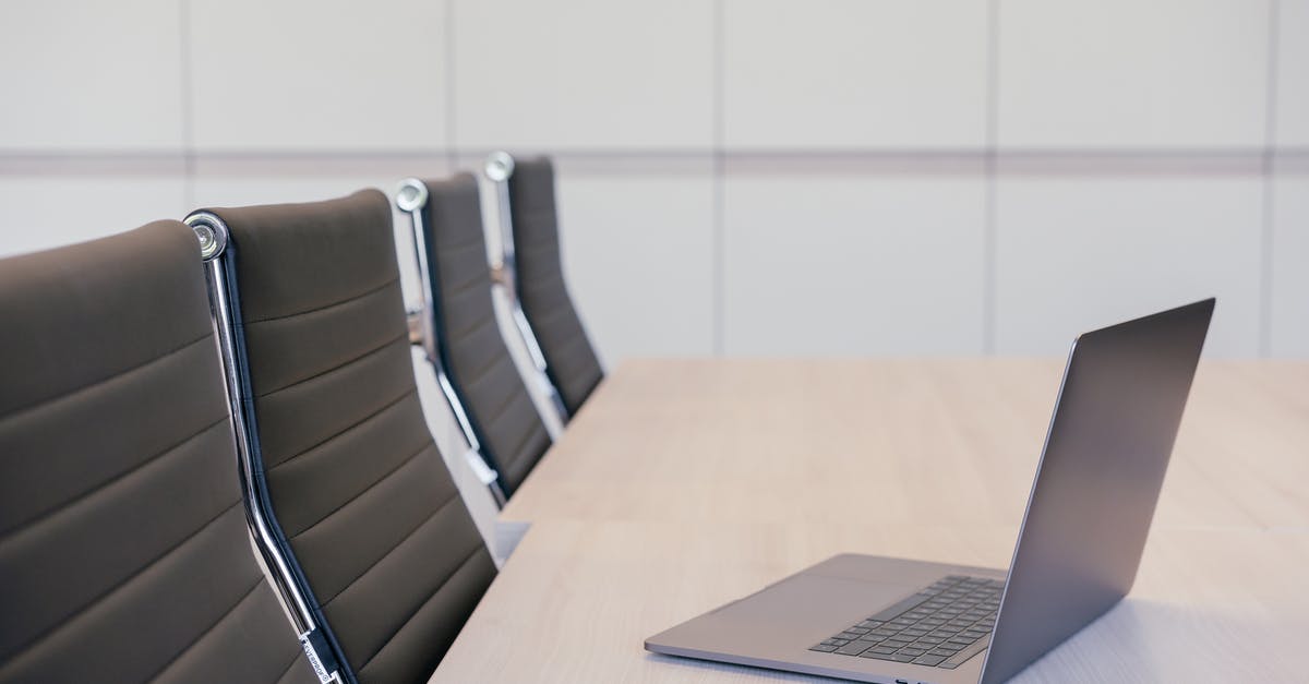 The capacity of a leather Quiver - Silver Laptop on Wooden Table with Office Chairs The capacity of a leather Quiver - Silver Laptop on Wooden Table with Office Chairs