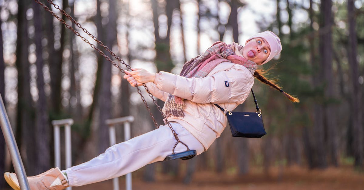 The daedric boots are bugging out - Woman in Pink Jacket and Beanie Sitting on a Swing The daedric boots are bugging out - Woman in Pink Jacket and Beanie Sitting on a Swing