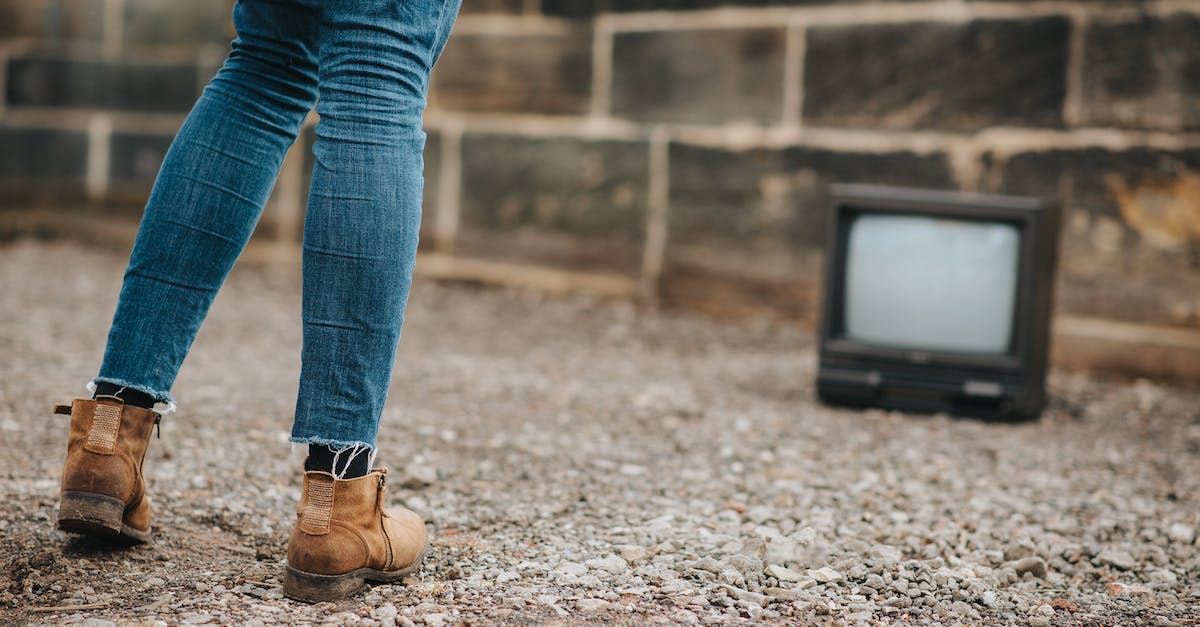 the mame.ini file path not used - Back view of anonymous female in jeans standing on ground against stone wall and old fashioned television on blurred background the mame.ini file path not used - Back view of anonymous female in jeans standing on ground against stone wall and old fashioned television on blurred background