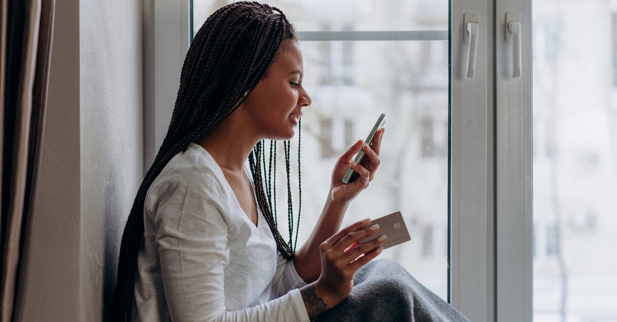 The purchasing email isn't mine - A Woman Talking on the Phone Holding a Credit Card The purchasing email isn't mine - A Woman Talking on the Phone Holding a Credit Card