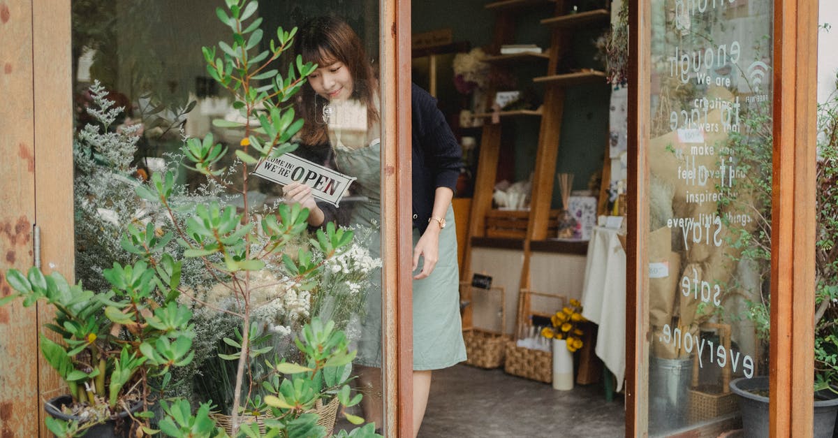 There's a Pokémon in the kebab store! Can I turn off augmented reality? - Positive young Asian female florist in apron standing near entrance and turning signboard on glass wall while working in modern floristry shop There's a Pokémon in the kebab store! Can I turn off augmented reality? - Positive young Asian female florist in apron standing near entrance and turning signboard on glass wall while working in modern floristry shop