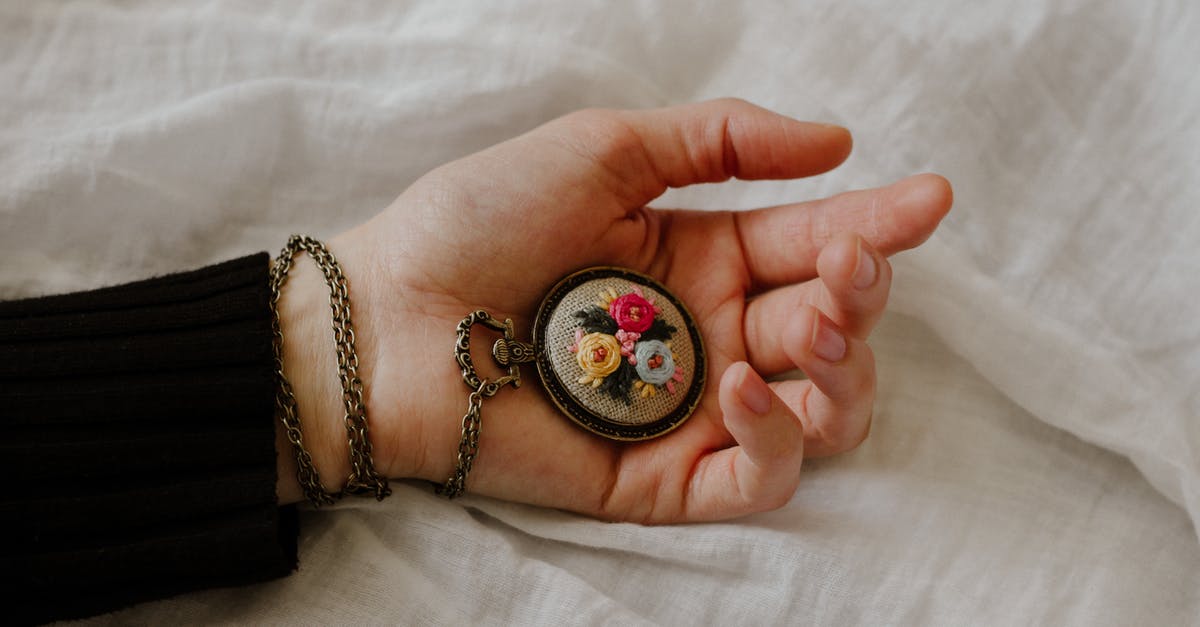 There’s only one hand on my Fez Clock - Top view of crop anonymous female with vintage chain watch on hand on white fabric There’s only one hand on my Fez Clock - Top view of crop anonymous female with vintage chain watch on hand on white fabric