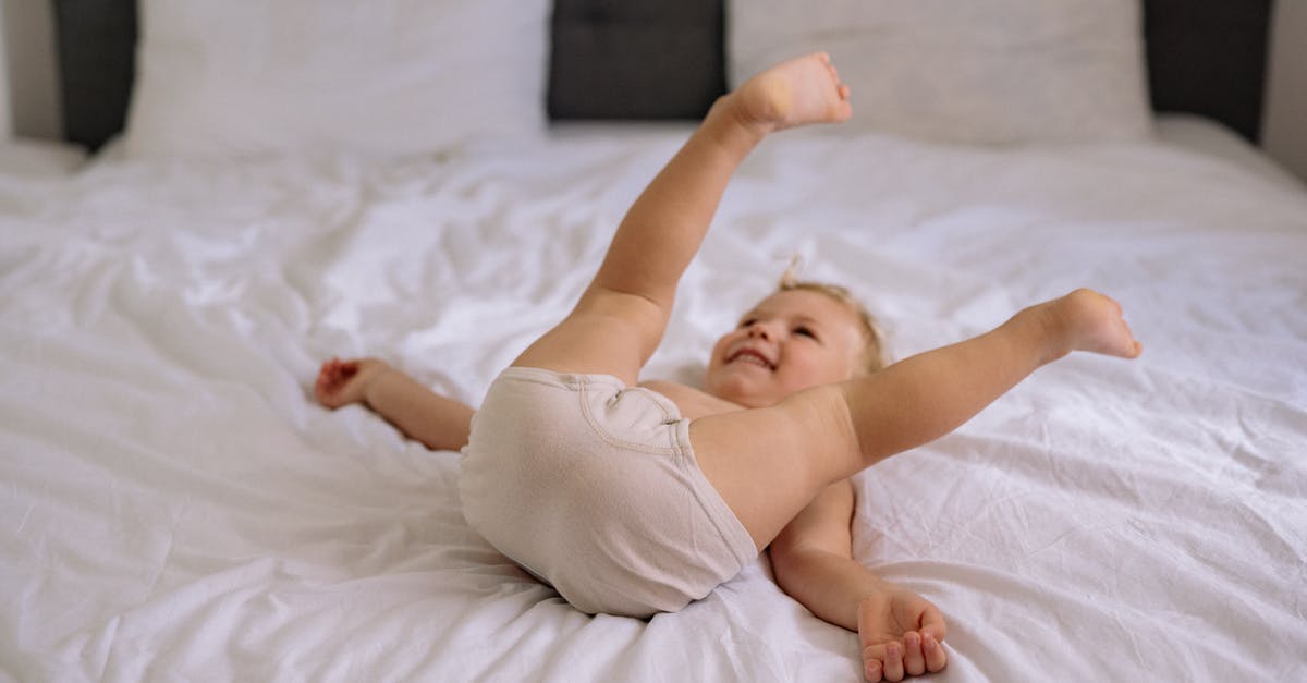 Time to deliver a baby [duplicate] - Baby in White Tank Top Lying on White Bed