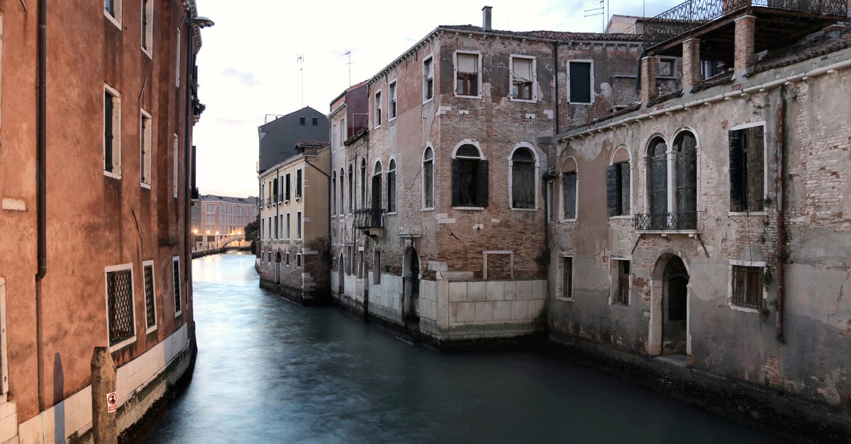 To get to a location first, is it better to leave early or wait to be over it? - Waterway with old buildings in Venice