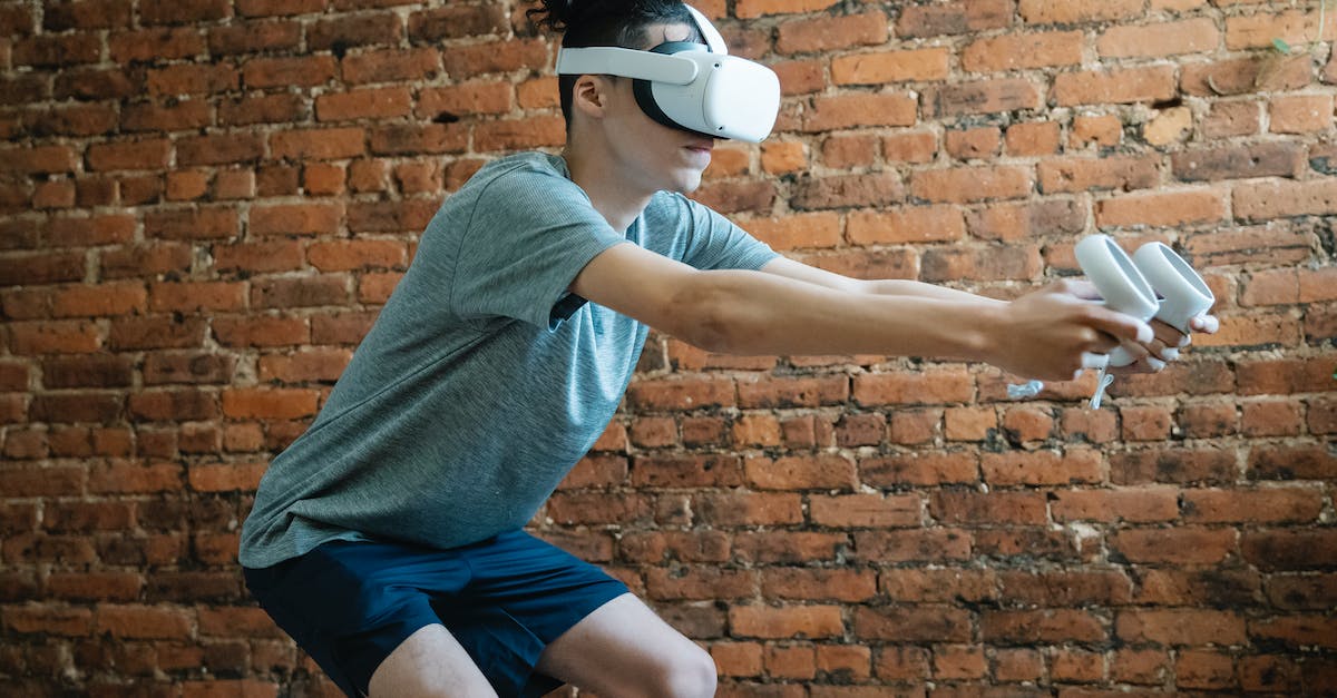 Transfer Mii from Wii U to the virtual Wii on the same console - Side view of unrecognizable young male in casual clothes using goggles of virtual reality controlling with console while standing in room Transfer Mii from Wii U to the virtual Wii on the same console - Side view of unrecognizable young male in casual clothes using goggles of virtual reality controlling with console while standing in room