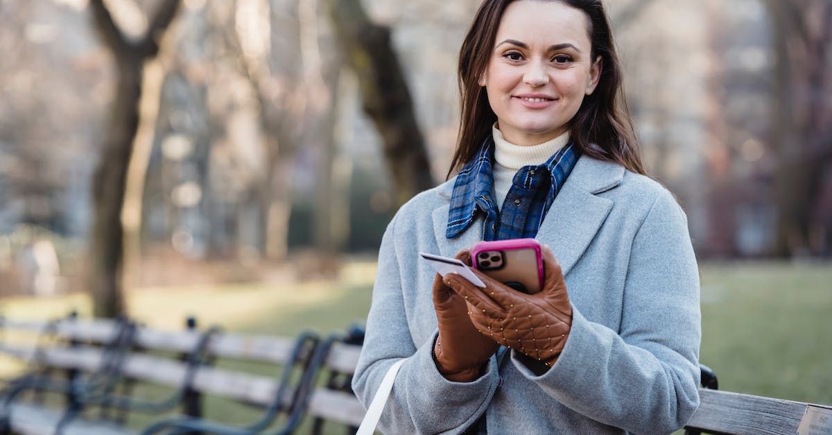 Transfer/Claim In-App Purchase to/on Another Device - Smiling woman using smartphone on spring city park Transfer/Claim In-App Purchase to/on Another Device - Smiling woman using smartphone on spring city park