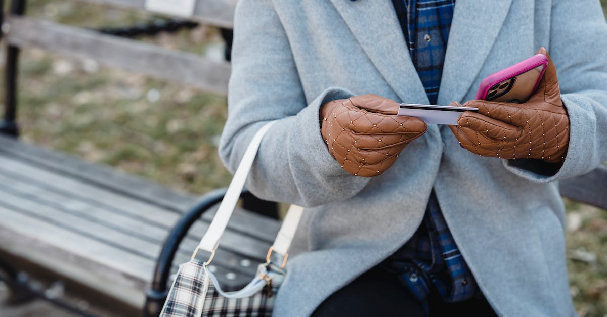 Transfer/Claim In-App Purchase to/on Another Device - Female sitting on bench and entering credit card detail on smartphone Transfer/Claim In-App Purchase to/on Another Device - Female sitting on bench and entering credit card detail on smartphone