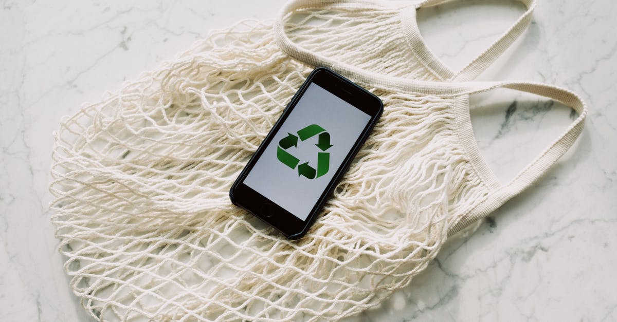 Transferring a Slime Rancher save - Overhead of smartphone with simple recycling sign on screen placed on white eco friendly mesh bag on marble table in room