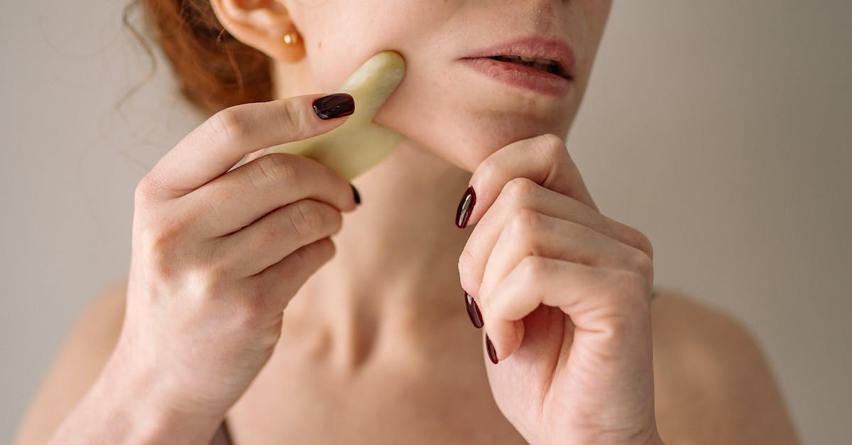 Tricks for using the rune stones? - Photograph of a Woman Using a Jade Stone on Her Face