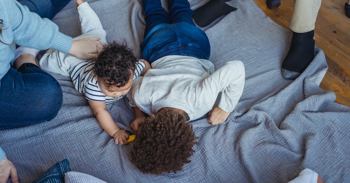 Trine 1 and 2 close right after launch - Multiethnic family playing on carpet on wooden floor Trine 1 and 2 close right after launch - Multiethnic family playing on carpet on wooden floor