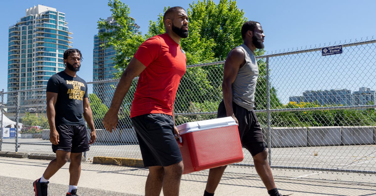 Troops walking out on me - Men in Sportswear Carrying a Cooler while Walking Troops walking out on me - Men in Sportswear Carrying a Cooler while Walking