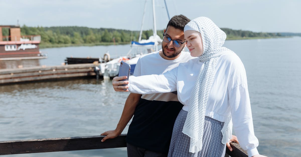 Trouble aiming the selfie - Woman in White Hijab and Black Dress Standing on Brown Wooden Dock