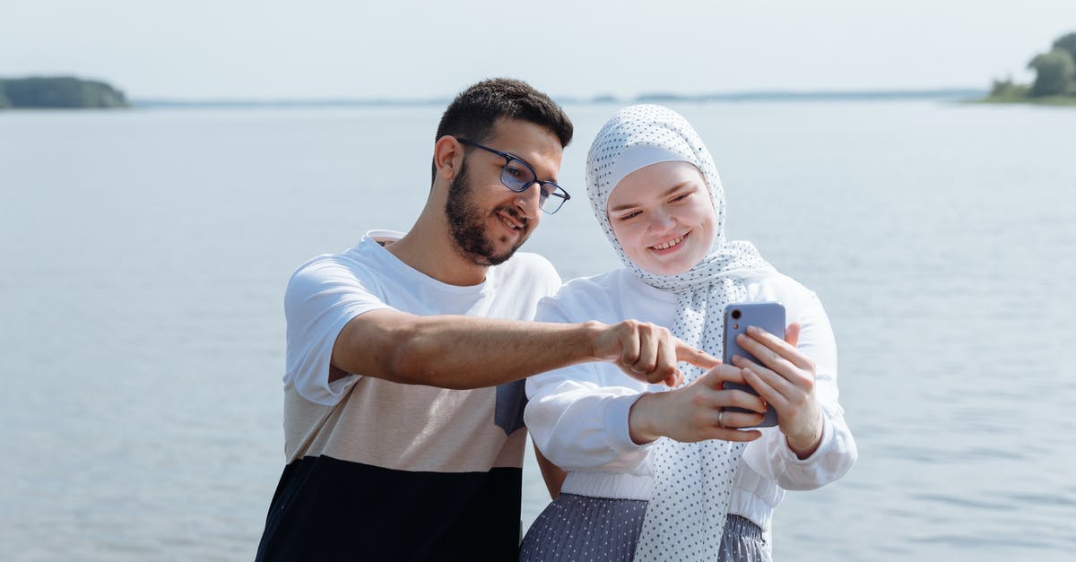 Trouble aiming the selfie - Man in White Crew Neck T-shirt Holding Woman in White Hijab
