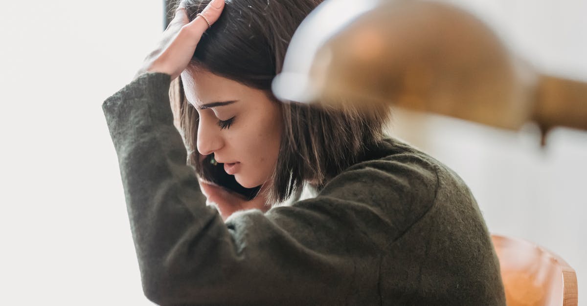 trouble connecting to steam servers - Side view of upset young ethnic female millennial with dark hair grabbing head with closed eyes while having phone conversation sitting on chair at home