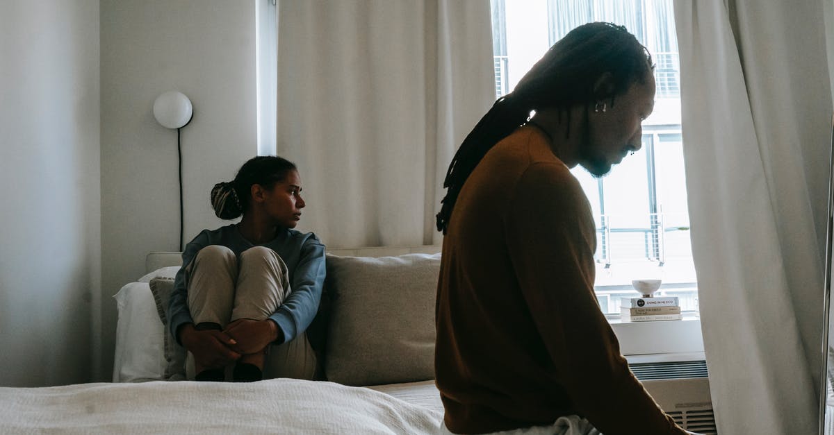Trouble launching Repton 1 and 2 on Windows 10 - Young frustrated black man with dreadlocks near unhappy girlfriend sitting on bed during conflict Trouble launching Repton 1 and 2 on Windows 10 - Young frustrated black man with dreadlocks near unhappy girlfriend sitting on bed during conflict