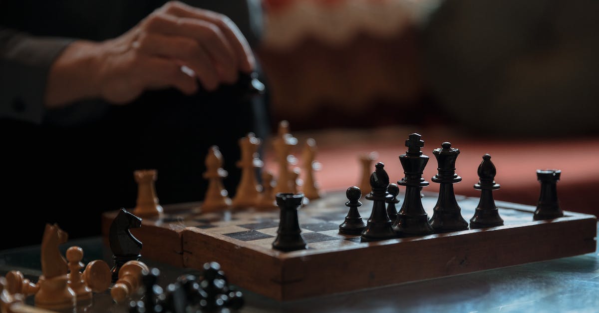 Tweedle battle in level 10 - Photo of a Person's Hand Near Chess Pieces