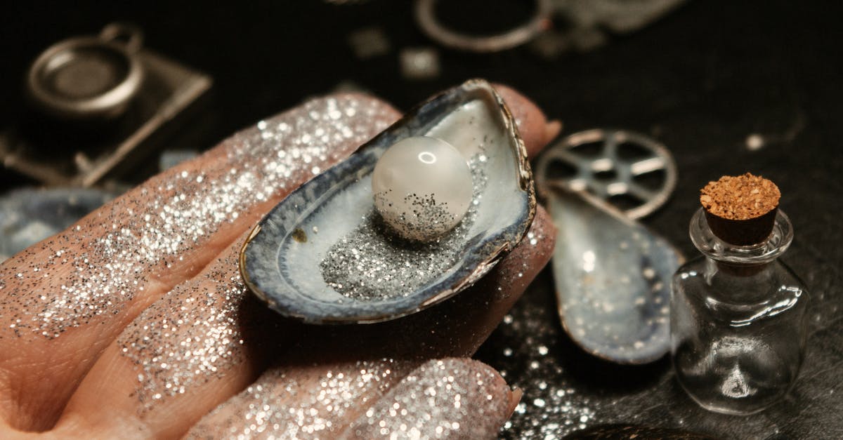 Twinkle, twinkle little star, how I wonder which game you are? - From above of female hand showing sparkling pearl in mollusc seashell on hand on blurred background