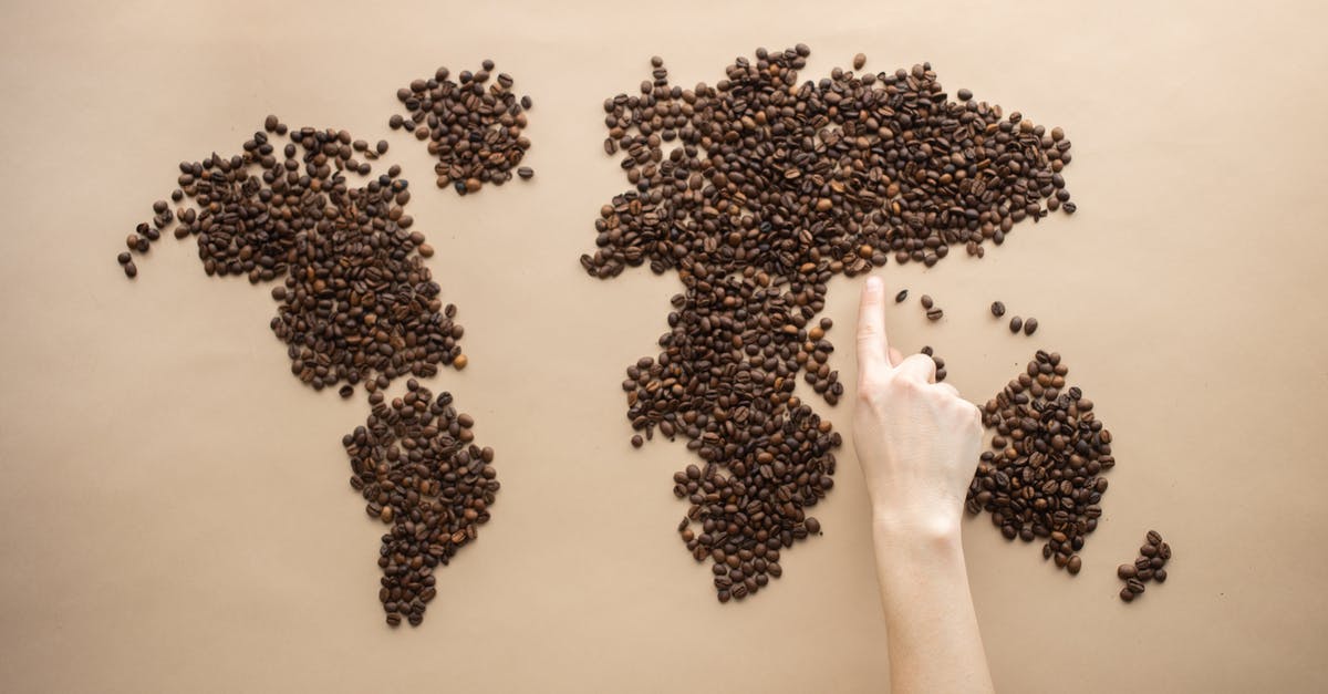 UFO map in Lil' Probe Inn indicates real points of interest? - Top view of crop person pointing finger at world map made of coffee beans on brown background