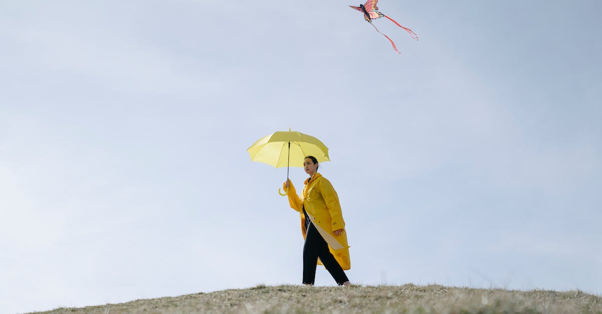 Umbrella Walking Cane? - Person in Yellow Coat Holding Yellow Umbrella