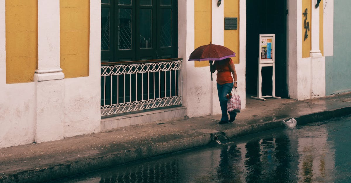Umbrella Walking Cane? - Person in White Shirt and Black Pants Holding Red Umbrella Walking on Sidewalk Umbrella Walking Cane? - Person in White Shirt and Black Pants Holding Red Umbrella Walking on Sidewalk