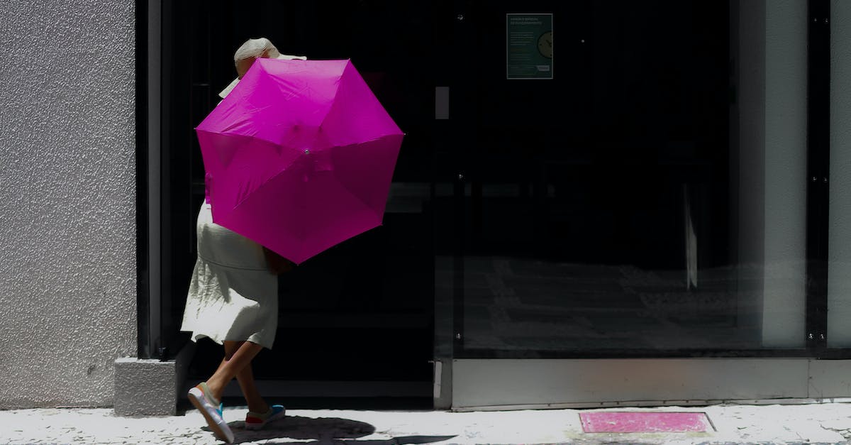 Umbrella Walking Cane? - Woman in White Dress Holding Pink Umbrella Walking on Sidewalk Umbrella Walking Cane? - Woman in White Dress Holding Pink Umbrella Walking on Sidewalk