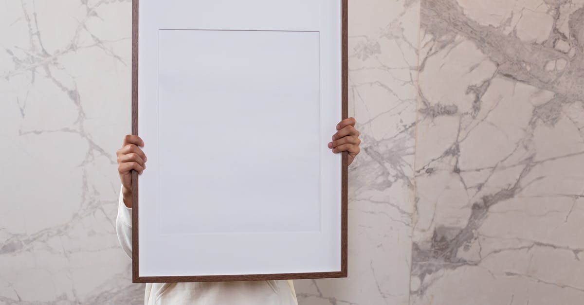 Unable to clear a mission to "buy something new in the stash"? - Crop anonymous person demonstrating white empty frame in hands near gray wall with patterns Unable to clear a mission to "buy something new in the stash"? - Crop anonymous person demonstrating white empty frame in hands near gray wall with patterns