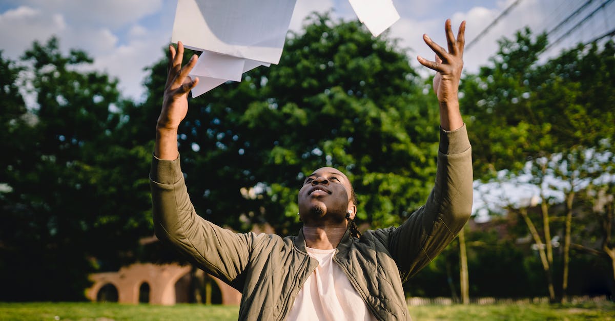 Unable to finish installation/update of Project Spark - Black man in casual clothes throwing sheets of paper up while working in city park in sunny day Unable to finish installation/update of Project Spark - Black man in casual clothes throwing sheets of paper up while working in city park in sunny day
