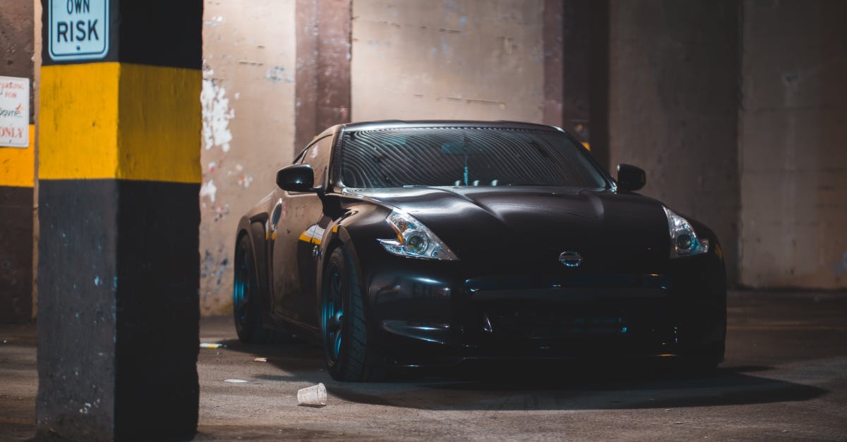 Underground Undercover - Can't warn Desdemona - Modern coupe car parked near concrete pillar with yellow stripe and warning sign in parking with shabby wall and messy floor