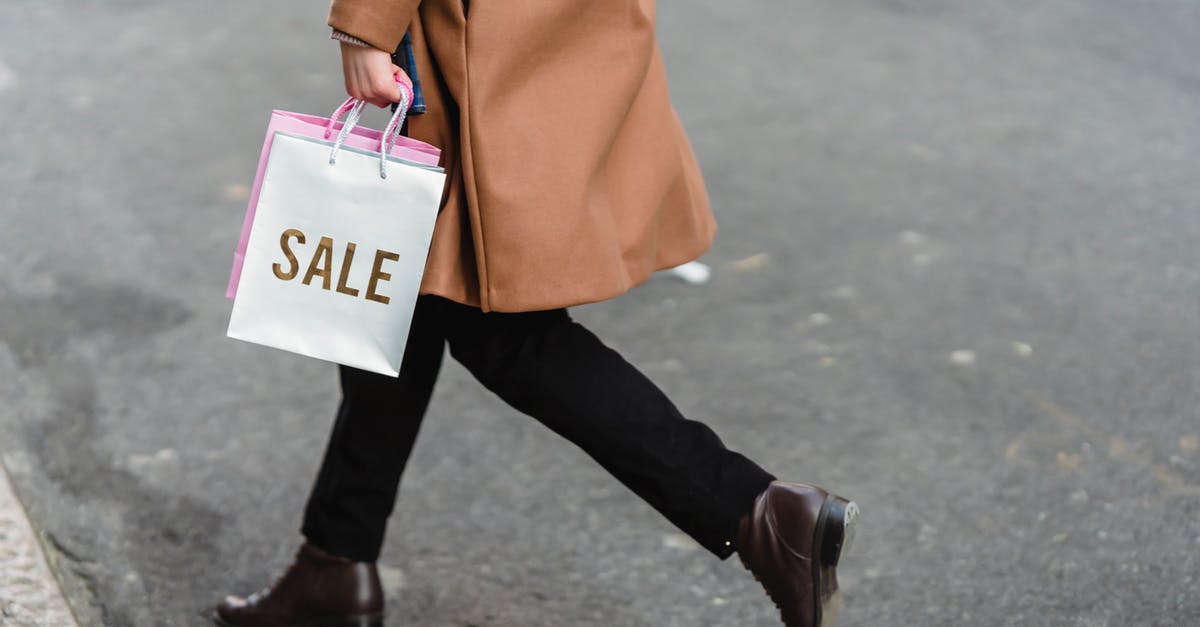 Undo path that leads to $20 DLC purchase on Fire Emblem Fates - Side view of unrecognizable female in trendy coat with shopping bags in hands strolling on asphalt road on street in city
