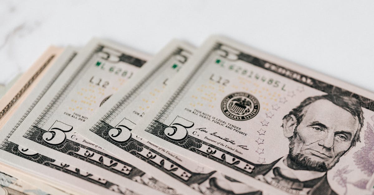 Unresponsive screen, except for when in power saving mode? - From above of pile of five dollar bills placed on white marble surface Unresponsive screen, except for when in power saving mode? - From above of pile of five dollar bills placed on white marble surface