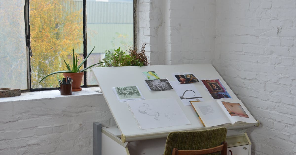 Updating Workshop Items - Opened books with various pictures and sketch placed on drawing table near window in workshop