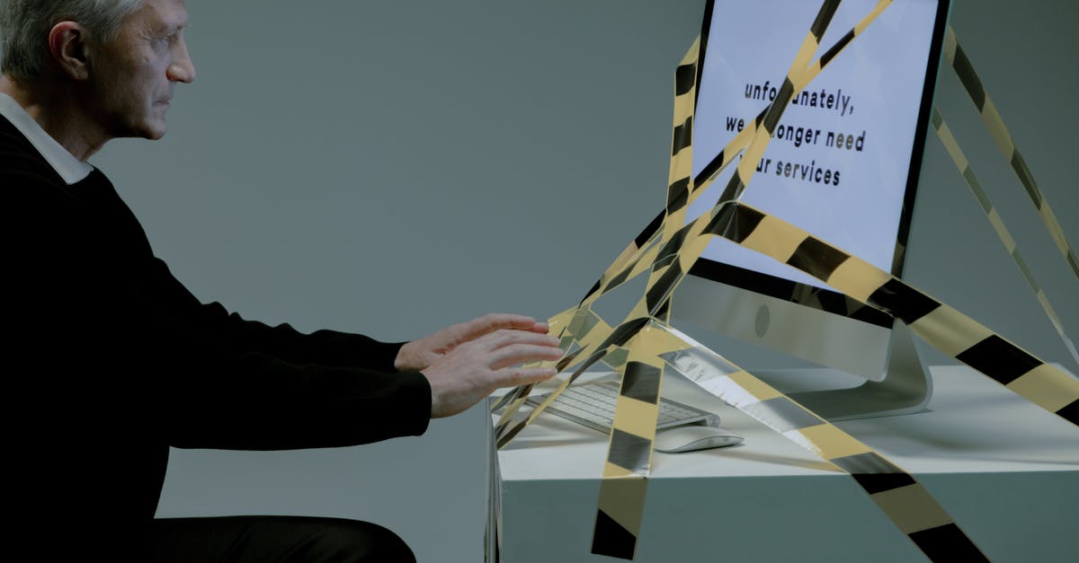 Useless upgrades? - Man typing on computer which is tied with a tape Useless upgrades? - Man typing on computer which is tied with a tape