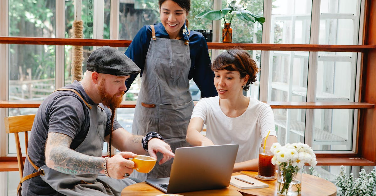 Using /effect on people with a certain amount of points on a scoreboard - Interested multiethnic cafeteria staff sharing laptop at work