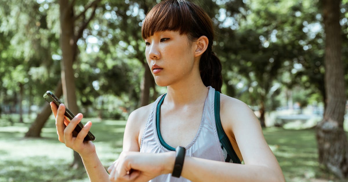 Using GameCube discs on wii (controller) - Concentrated young Asian woman using smartphone in park