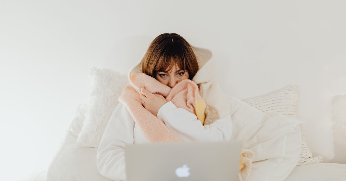 Using Spotify on Zombies 5K - Woman Wrapped in a Blanket Using a Laptop in a Bed Using Spotify on Zombies 5K - Woman Wrapped in a Blanket Using a Laptop in a Bed