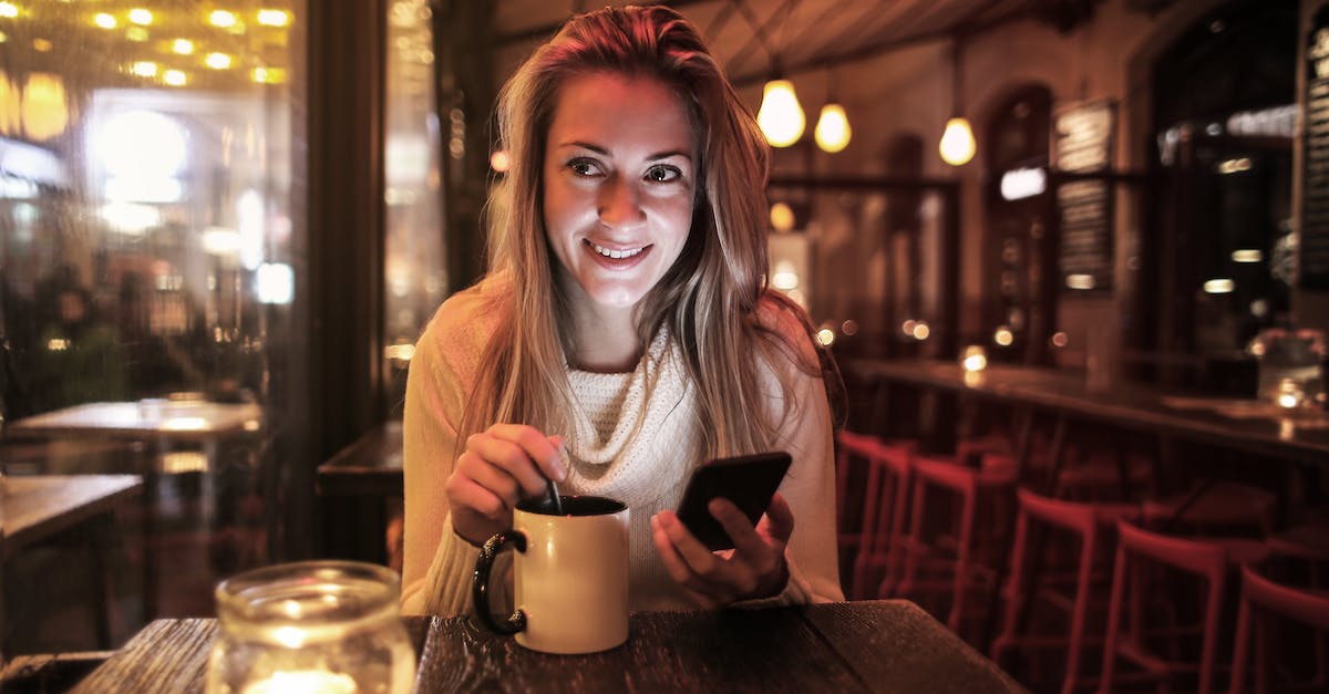 Using testfor command to constantly fill hunger bar - Delighted woman with cup of beverage browsing smartphone in cafe Using testfor command to constantly fill hunger bar - Delighted woman with cup of beverage browsing smartphone in cafe
