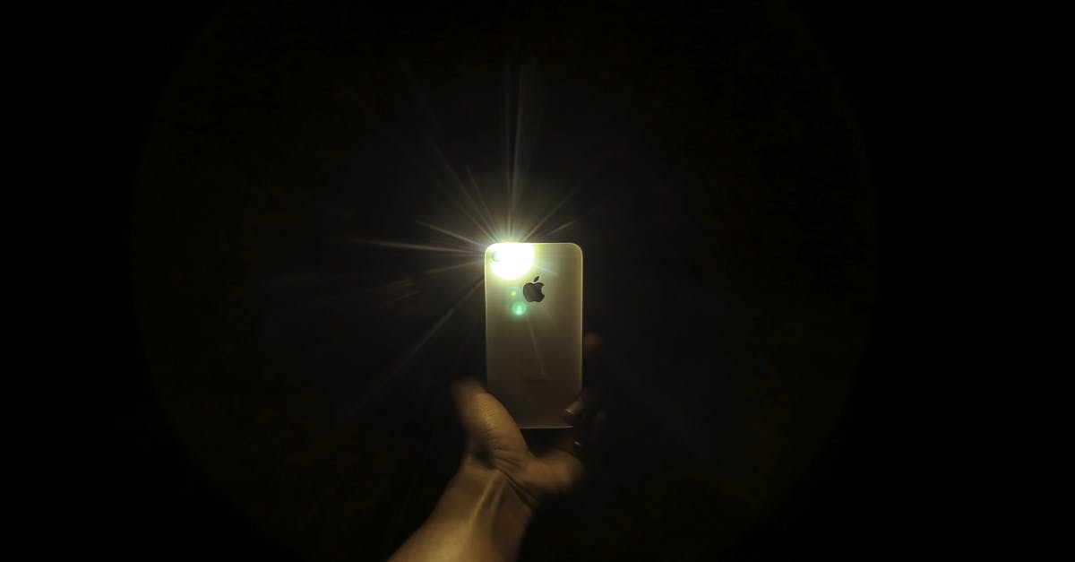 Using testfor to give a potion effect - Crop anonymous person demonstrating modern mobile phone with bright flashlight in dark room