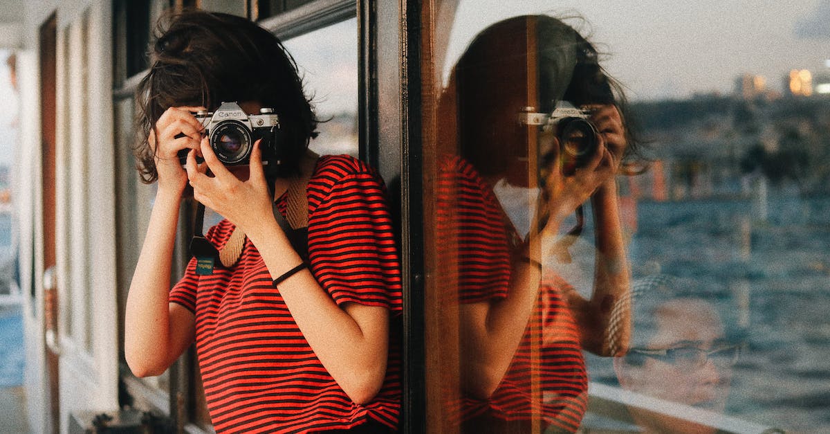 Using the collector on the rescue ship? - Woman in casual clothes standing near windows on ship deck while taking pictures on camera Using the collector on the rescue ship? - Woman in casual clothes standing near windows on ship deck while taking pictures on camera