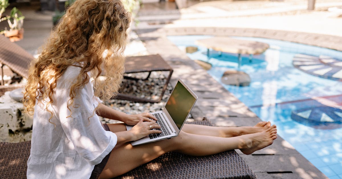 Using transparency in Minecraft. How? [duplicate] - From above side view of unrecognizable barefoot female traveler with curly hair typing on netbook while resting on sunbed near swimming pool on sunny day